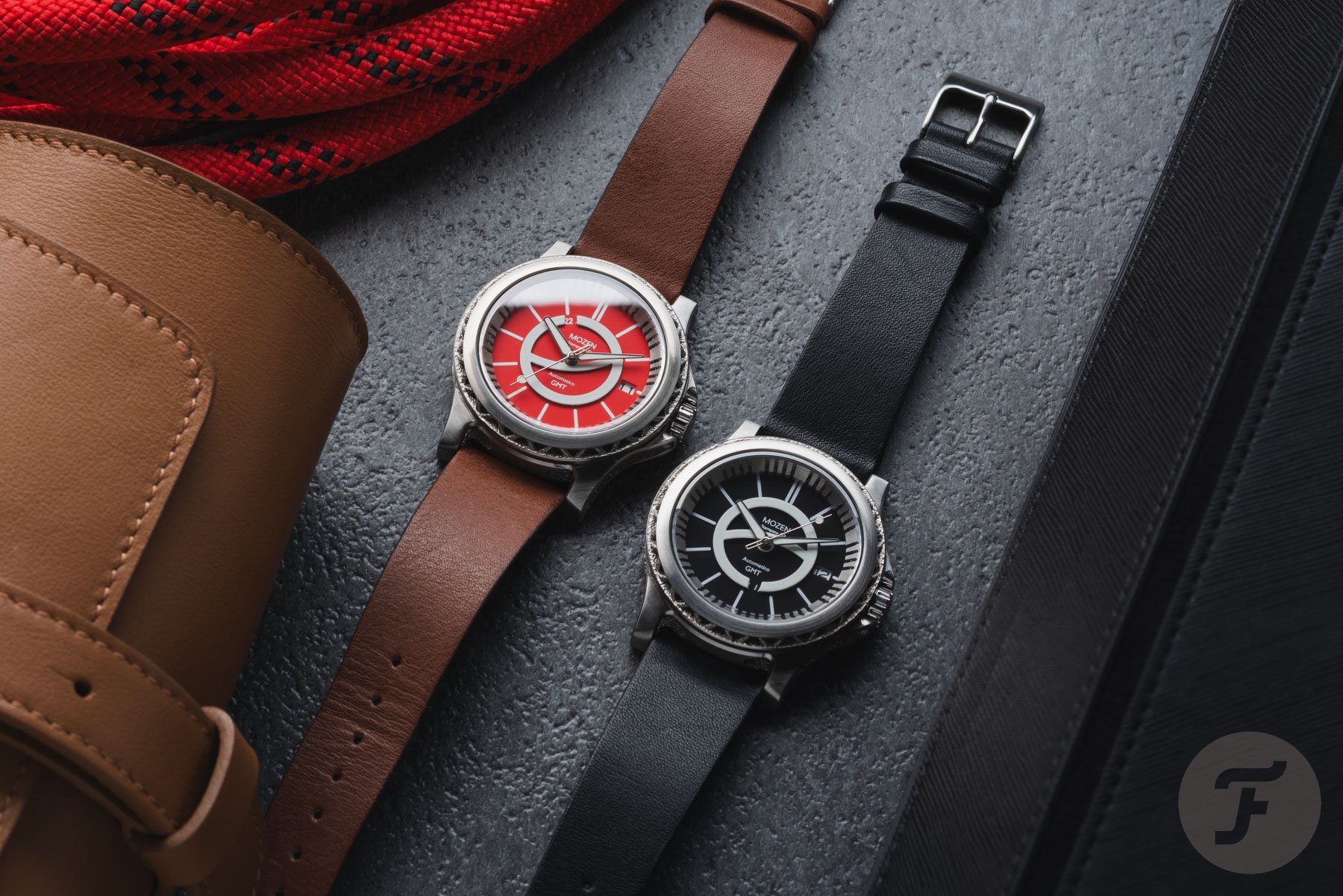 Mozen GMT1 Rosso and Nero side by side, flat-lay with rope, watch roll, and tray